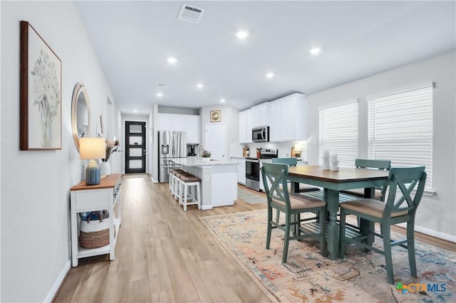 dining space featuring light wood-type flooring, visible vents, baseboards, and recessed lighting