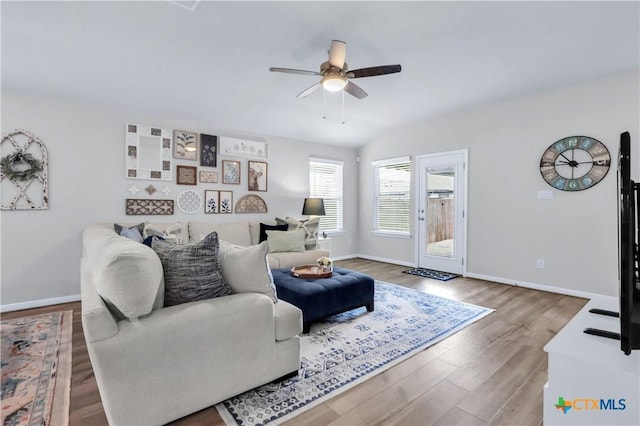 living area with baseboards, wood finished floors, and a ceiling fan