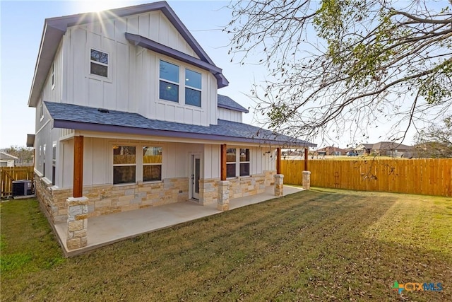 back of property featuring cooling unit, a patio area, and a yard