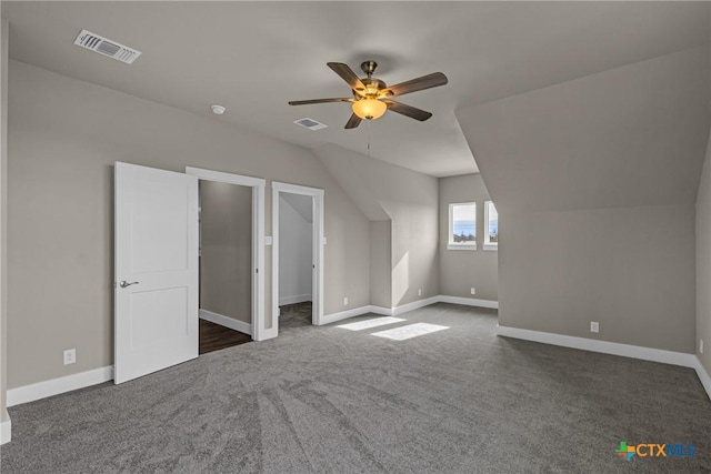 additional living space with ceiling fan, lofted ceiling, and dark colored carpet