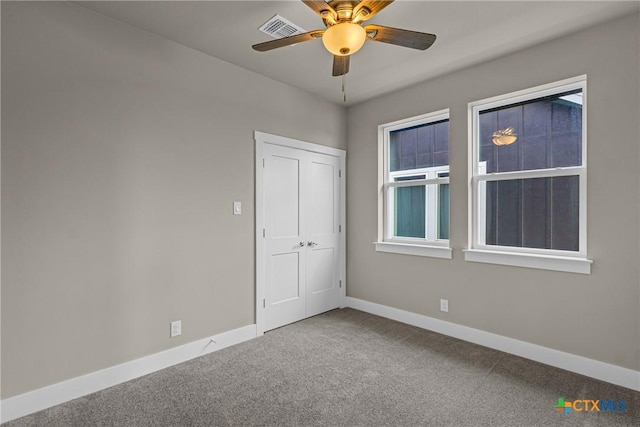 carpeted spare room with ceiling fan