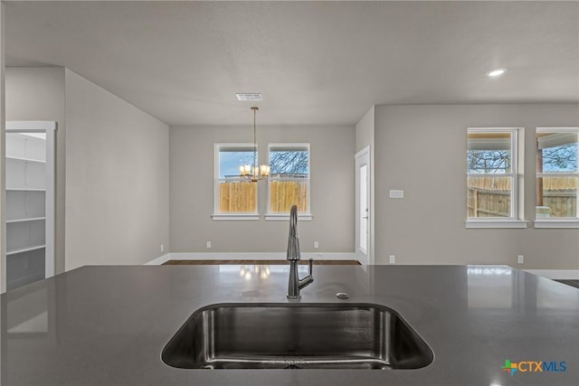 kitchen featuring an inviting chandelier, pendant lighting, and sink