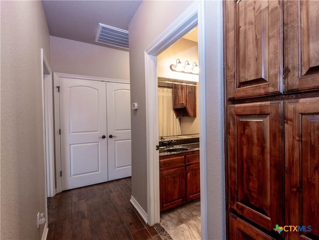 hallway featuring sink and dark hardwood / wood-style floors