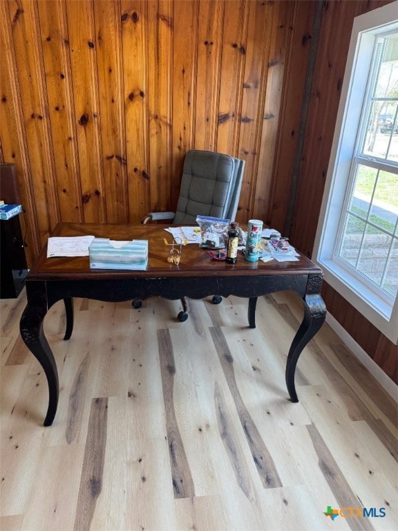 office space with wood finished floors and wood walls