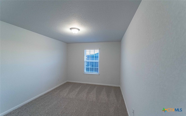 unfurnished room featuring carpet flooring, a textured ceiling, and baseboards