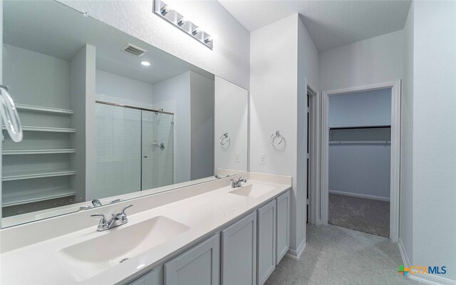 bathroom with a stall shower, visible vents, a sink, and a spacious closet