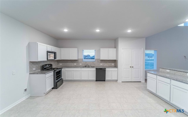 kitchen with a sink, black appliances, white cabinets, and backsplash