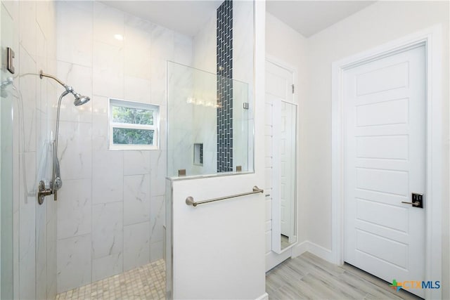 bathroom featuring a tile shower and hardwood / wood-style flooring