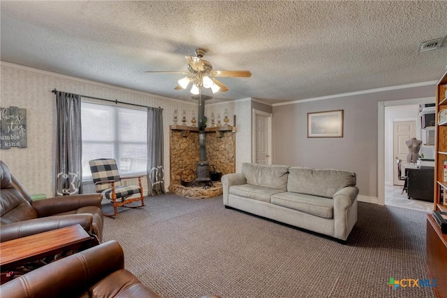 carpeted living room with a wood stove, a textured ceiling, visible vents, crown molding, and a ceiling fan