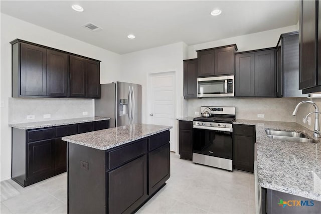 109 Cypress Hills Rd, San Marcos, TX 78666 - kitchen with appliances with stainless steel finishes, a center island, light stone counters, backsplash, and recessed lighting