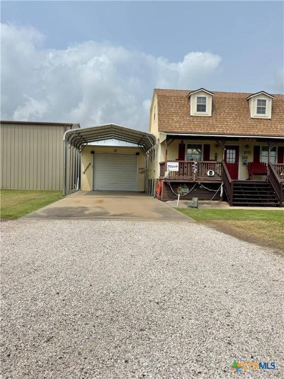 604 N 14th St, Port Oconnor, TX 77982 - view of front facade with gravel driveway, a carport, a porch, and a shingled roof