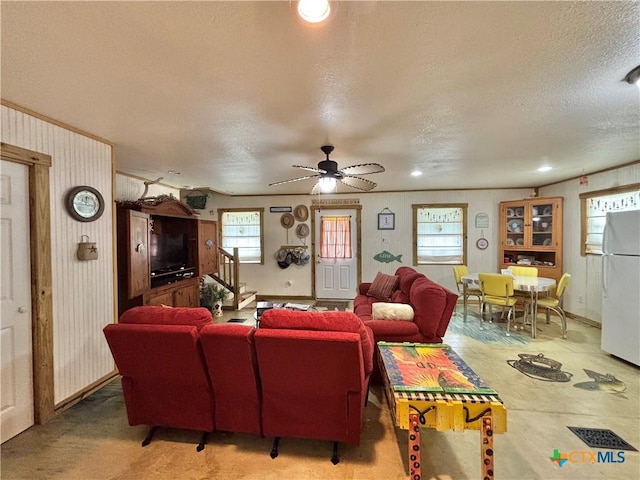 604 N 14th St, Port Oconnor, TX 77982 - living room featuring a textured ceiling, stairs, ceiling fan, and baseboards