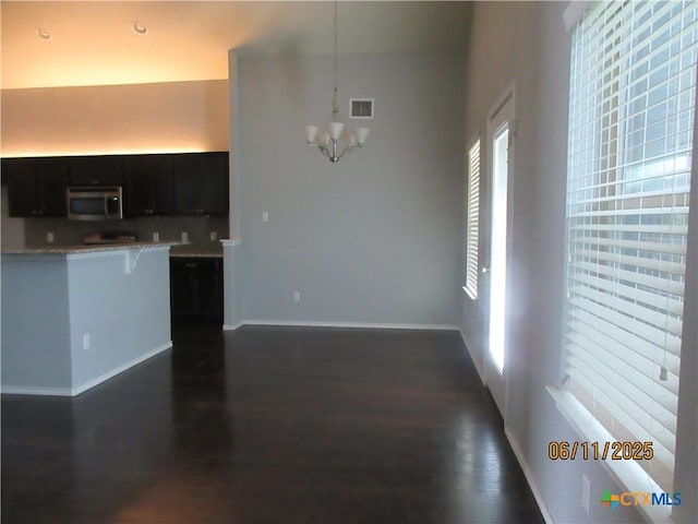 1418 Fawn Lily Dr, Temple, TX 76502 - kitchen featuring stainless steel microwave, a kitchen bar, a chandelier, light countertops, and dark wood finished floors
