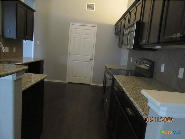 1418 Fawn Lily Dr, Temple, TX 76502 - kitchen with black electric range oven, stainless steel microwave, tasteful backsplash, and light stone counters