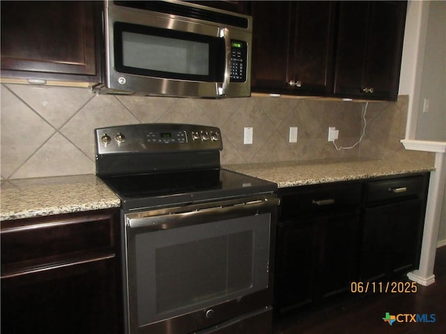 1418 Fawn Lily Dr, Temple, TX 76502 - kitchen featuring stainless steel microwave, black / electric stove, backsplash, dark brown cabinetry, and light stone countertops