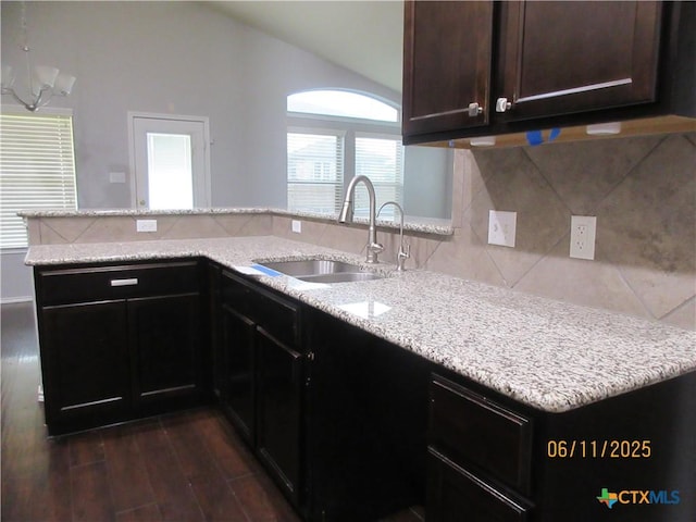1418 Fawn Lily Dr, Temple, TX 76502 - kitchen featuring a peninsula, backsplash, dark wood finished floors, lofted ceiling, and light stone counters