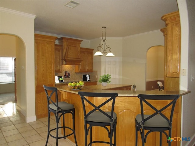 kitchen featuring arched walkways, visible vents, backsplash, and light tile patterned flooring