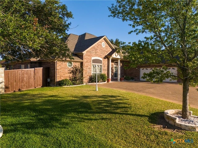 view of front facade with driveway, roof with shingles, fence, a front lawn, and brick siding