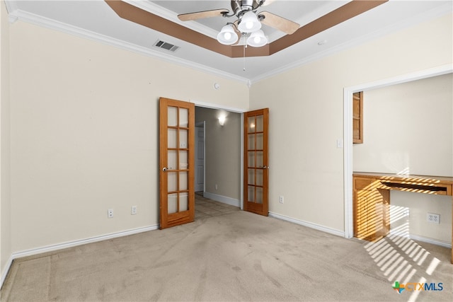 carpeted spare room featuring a tray ceiling, french doors, crown molding, visible vents, and baseboards