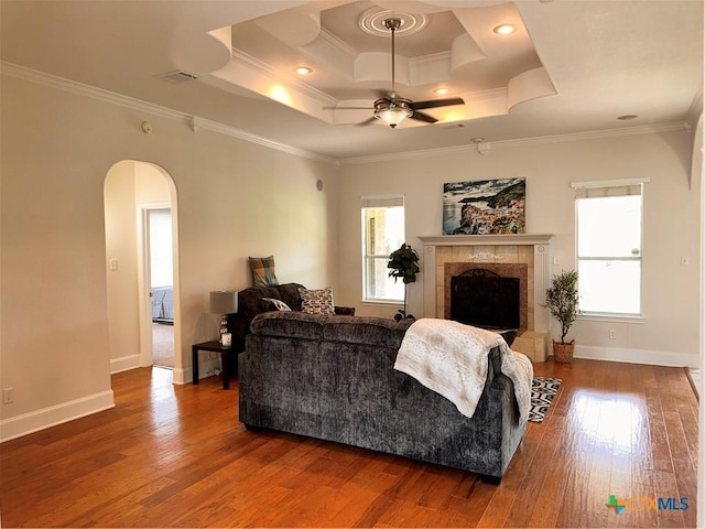 1004 Shady Hollow Ct, Nolanville, TX 76559 - living area featuring arched walkways, wood finished floors, a tray ceiling, ceiling fan, and crown molding