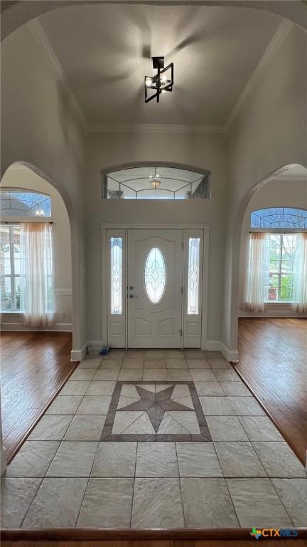 1004 Shady Hollow Ct, Nolanville, TX 76559 - foyer entrance featuring arched walkways, a high ceiling, ornamental molding, and inlaid floor details
