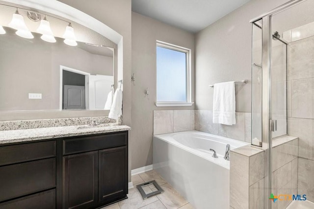 bathroom featuring shower with separate bathtub, vanity, and tile patterned floors