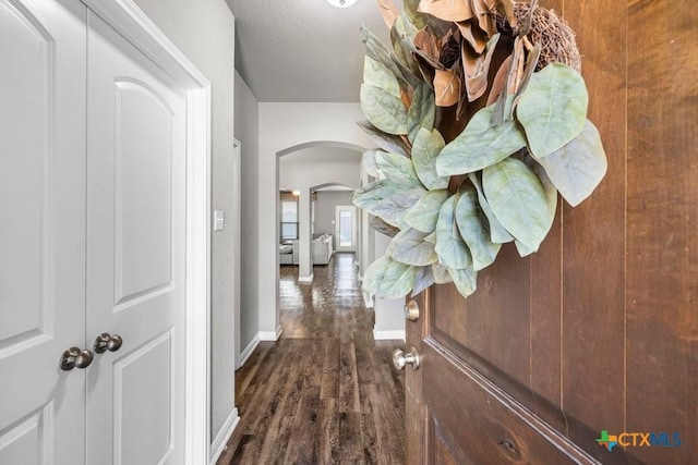 hallway featuring dark hardwood / wood-style flooring and a textured ceiling