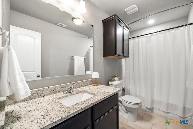 full bathroom featuring tile patterned floors, vanity, toilet, and shower / bath combo with shower curtain