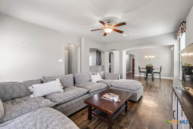 living room with dark hardwood / wood-style floors and ceiling fan with notable chandelier