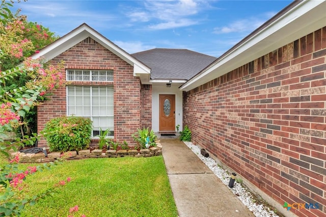 106 Hamlet Ct, Victoria, TX 77901 - entrance to property with brick siding, a shingled roof, and a lawn