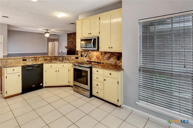 106 Hamlet Ct, Victoria, TX 77901 - kitchen with stainless steel appliances, cream cabinets, a peninsula, a ceiling fan, and tasteful backsplash