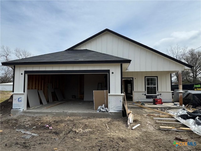 rear view of property with covered porch and a garage