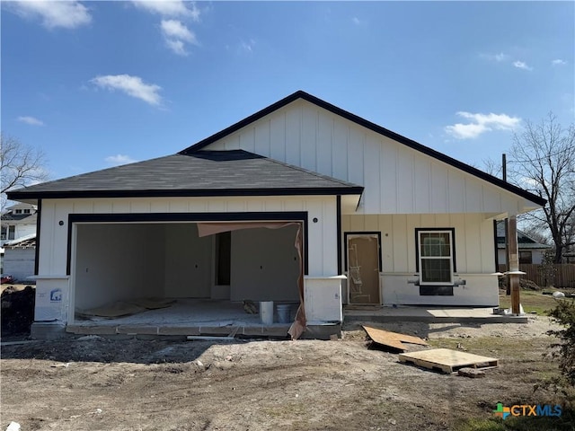 back of house with a garage and covered porch