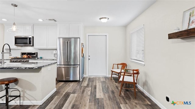 1406 Shannon Cir, New Braunfels, TX 78130 - kitchen featuring stainless steel appliances, a breakfast bar area, dark wood-type flooring, backsplash, and recessed lighting