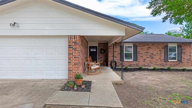 1406 Shannon Cir, New Braunfels, TX 78130 - view of front of house featuring brick siding, driveway, an attached garage, and a shingled roof