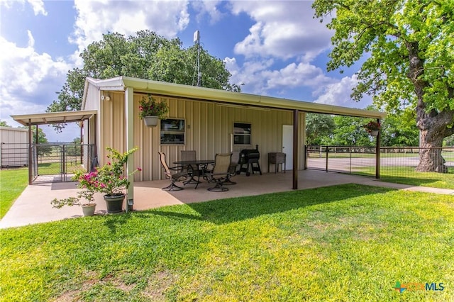 exterior space with a lawn, a patio, fence, and a gate
