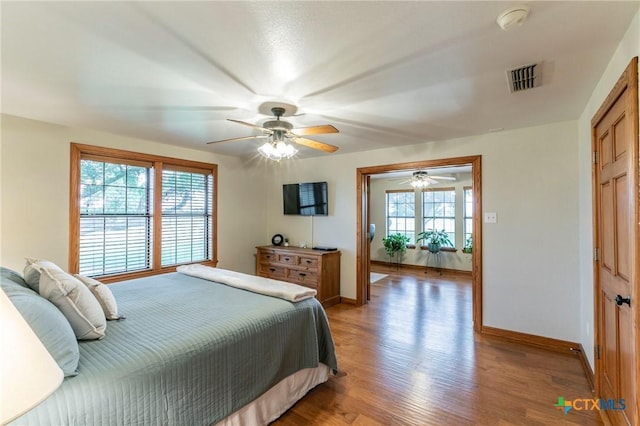 bedroom featuring a ceiling fan, baseboards, visible vents, and light wood-type flooring