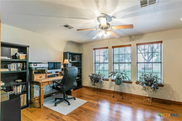 office with ceiling fan, wood finished floors, and visible vents