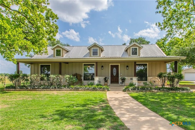 view of front of home featuring a front lawn, board and batten siding, covered porch, and metal roof