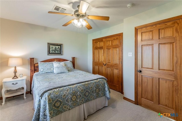 bedroom with visible vents, a closet, light carpet, baseboards, and ceiling fan