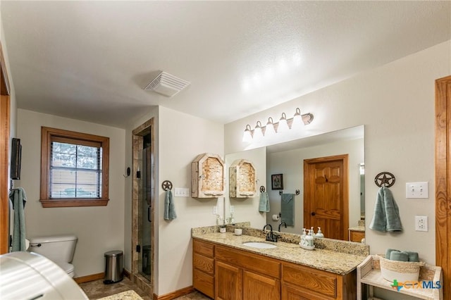 full bathroom with vanity, a shower stall, toilet, and visible vents
