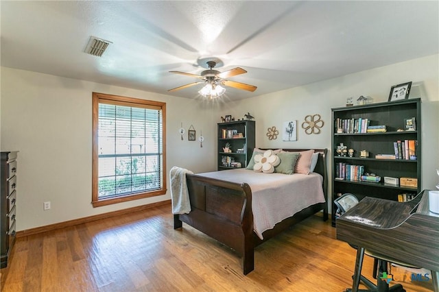 bedroom with visible vents, baseboards, ceiling fan, and wood finished floors