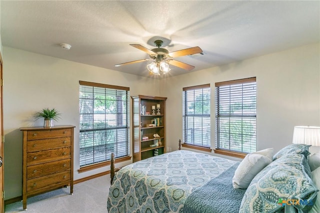 bedroom with baseboards, ceiling fan, and light carpet