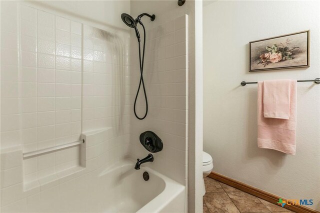 full bath with baseboards, tile patterned floors, washtub / shower combination, and toilet