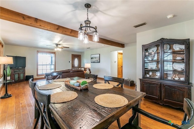 dining room with visible vents, light wood-style flooring, ceiling fan, and beamed ceiling