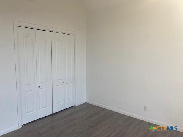 unfurnished bedroom featuring a closet and dark hardwood / wood-style floors