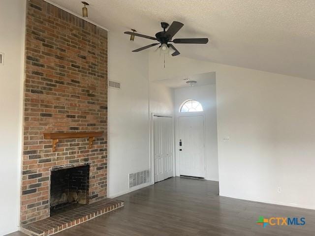 entryway featuring a textured ceiling, ceiling fan, dark hardwood / wood-style flooring, and a fireplace