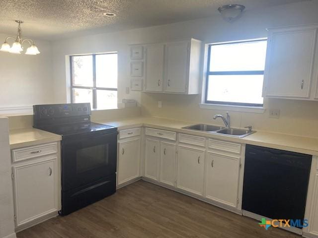 kitchen with sink, white cabinets, an inviting chandelier, hanging light fixtures, and black appliances