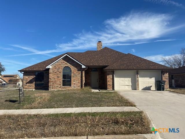 ranch-style house featuring a front lawn and a garage