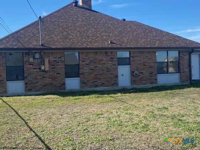 rear view of property with a lawn